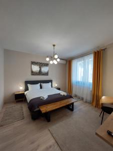 a bedroom with a large bed and a large window at Mandarin Premium Apartments in Târgu-Mureş