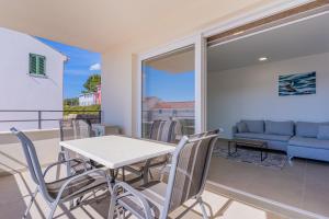 a table and chairs on a balcony with a couch at Blue Pearl Apartment in Cres