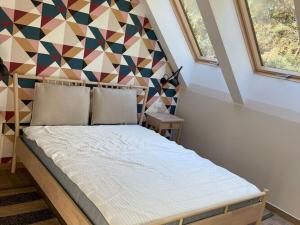 ein Schlafzimmer mit einem Bett mit einer geometrischen Wand in der Unterkunft Modern Holiday Home in Kamień with a View and Garden in Kamień