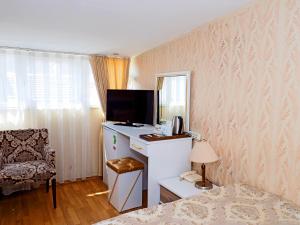 a room with a bed and a desk with a television at Nagehan Hotel Old City in Istanbul