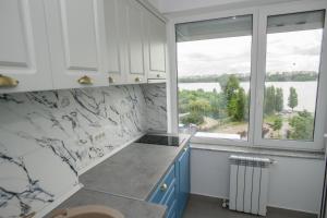 Una cocina con gabinetes blancos y una ventana grande. en C&Y Marco Apartments, en Mamaia 39 fotos más