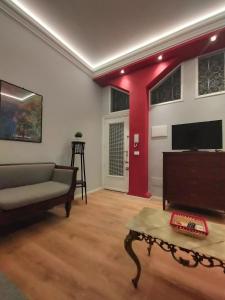 uma sala de estar com um sofá e uma televisão de ecrã plano em Start Living House em Taormina