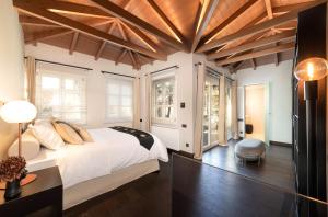 um quarto com uma cama branca e tectos em madeira em The New Era Luxury Living em Heraclião