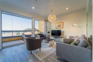 a living room with a couch and a table and a tv at Aurinkoranta Apartments by Hiekka Booking in Kalajoki