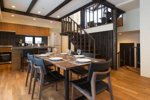 uma sala de jantar e cozinha com mesa e cadeiras em Tahoe Lodge by H2 Life em Niseko
