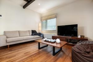 a living room with a couch and a tv at Tahoe Lodge by H2 Life in Niseko