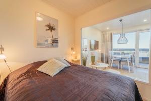 a bedroom with a large bed and a dining room at Aurinkoranta Apartments by Hiekka Booking in Kalajoki