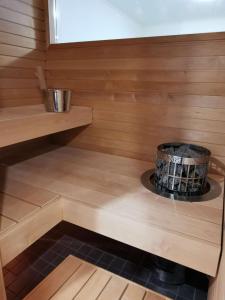a sauna with a stove in a wooden cabin at Aurinkoranta Apartments by Hiekka Booking in Kalajoki