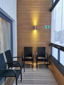 a group of chairs sitting on a porch at Aurinkoranta Apartments by Hiekka Booking in Kalajoki