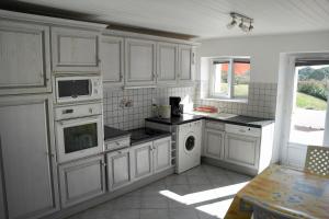 cocina con armarios blancos y fogones en Petite maison vendeenne cinq personnes pour des vacances reposantes, en Commequiers