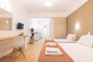 ein Hotelzimmer mit 2 Betten und einer Küche in der Unterkunft Nel Mare Studios in Laganas