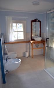 uma casa de banho com 2 lavatórios e um espelho em Villa Iolanda em Merano