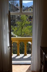 an open door to a balcony with a yellow railing at Villa Iolanda in Merano