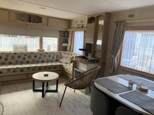 a living room with a couch and a table at Beach House Giethoorn in Wanneperveen