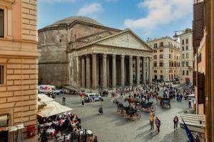 un gruppo di persone in piedi in una strada di fronte a un edificio di Maison Leonardo al Pantheon a Roma