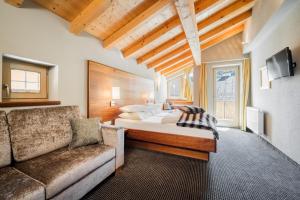 um quarto com uma cama e um sofá em Villa Bergfried em Tux
