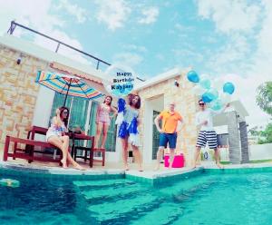 a group of people standing next to a swimming pool at Rocky Party Pool Villa Huahin 3 Bedrooom With BBQ & Karaoke in Hua Hin