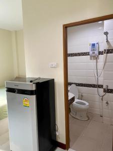 a bathroom with a toilet and a phone on the wall at Pepa Guest House in Ko Tao