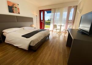 1 dormitorio con 1 cama, TV y mesa en Hotel Serpiano, en Serpiano