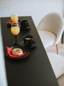 a black table with two glasses of orange juice and a cookie at Apartman Stari Toranj II in Vukovar