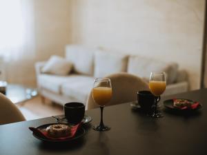 Twee glazen sinaasappelsap en een bord eten op tafel. bij Apartman Stari Toranj II in Vukovar