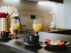 two glasses of orange juice and a plate of food on a kitchen counter at Apartman Stari Toranj II in Vukovar