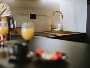 a kitchen counter with a sink and a glass of orange juice at Apartman Stari Toranj II in Vukovar