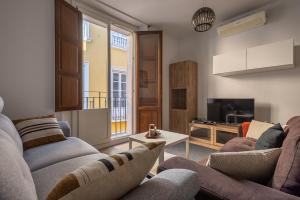 een woonkamer met twee banken en een tv bij Puerta Real Centro Apartment in Granada