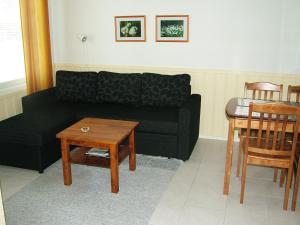 a living room with a black couch and a table at Yllästar 305 Apartment in Äkäslompolo