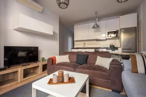 een woonkamer met een bank en een tafel bij Puerta Real Centro Apartment in Granada