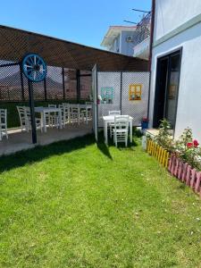 patio z białymi stołami i krzesłami na dziedzińcu w obiekcie Azra Apart & Otel w mieście Gokceada