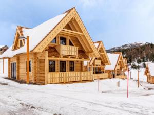 a log home with snow on the ground at Les Chalets de L'Ecrin in La Joue du Loup