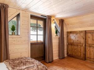 a bedroom with wooden walls and a window and a bed at Les Chalets de L'Ecrin in La Joue du Loup