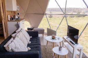 a living room with a couch and a tv in a tent at Wiosna Glamp in Wiosna