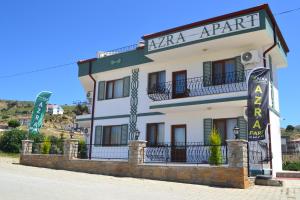 ein großes weißes Gebäude mit einem Schild drauf in der Unterkunft Azra Apart & Otel in Gokceada Town