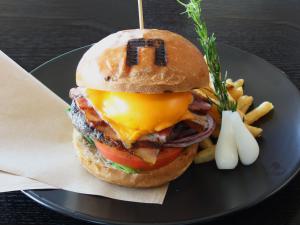a hamburger and french fries on a black plate at The Gate Hotel Asakusa Kaminarimon by Hulic in Tokyo