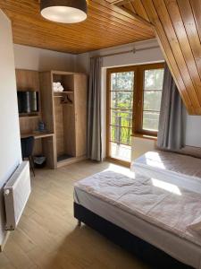 - une chambre avec un grand lit et une fenêtre dans l'établissement Ośrodek Agroturystyczny Zacisze, à Giewartów