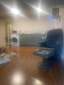 a living room with a chair and a kitchen at Killarney Saoirse Apartment in Killarney