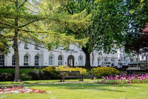 a park filled with lots of flowers on a sunny day at Queens Hotel Cheltenham in Cheltenham