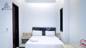 a bedroom with a white bed with white sheets and pillows at Regentown Near ICE BSD in Tangerang
