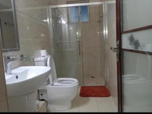 a bathroom with a toilet and a sink and a shower at Casa Tranquilla - JKIA in Nairobi