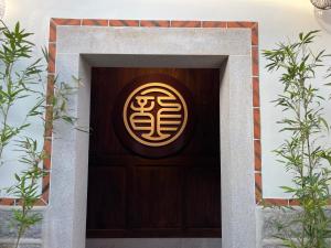 una puerta de madera con un letrero chino. en 新龍頭古厝行館 Shin Long Tou B&B, en Jinning