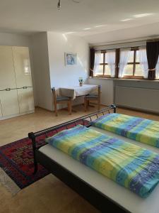 two beds in a room with a kitchen and a table at Ferienwohnung Agnes Mayer in Riedenburg