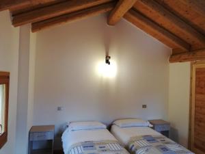 two beds in a room with a ceiling with beams at La Caneveta al Piave in Valdobbiadene