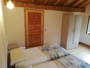 a bedroom with two beds and a wooden door at La Caneveta al Piave in Valdobbiadene +25 photos