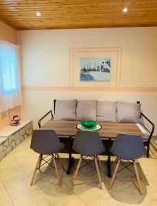 una mesa con sillas y un sofá en una habitación en Helen s house, en Komílion