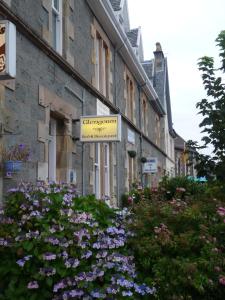 ein Schild an der Seite eines Gebäudes mit Blumen in der Unterkunft Glengorm Guest House in Oban