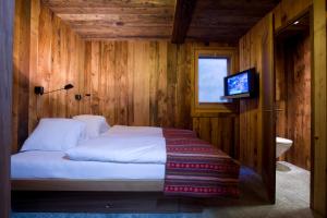 1 dormitorio con 1 cama y TV en Chalet Z'Gogwärgji, en Zermatt