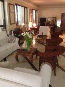 a living room with couches and tables and chairs at Hotel Alcione in Marina di Massa