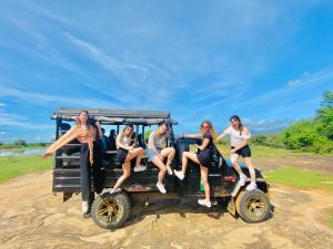 un grupo de personas sentadas en la parte trasera de un jeep en Pearl White House en Udawalawe